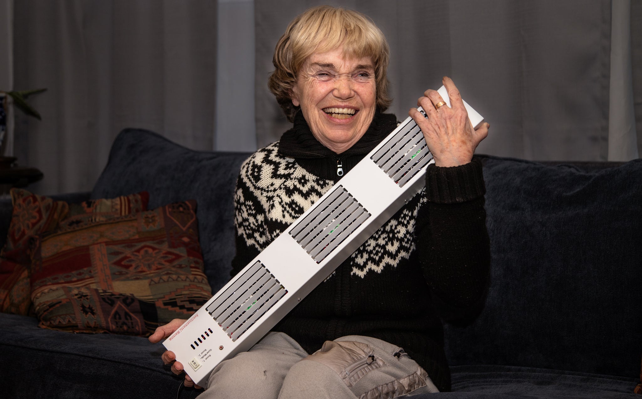 A smiling woman holding a Baseboard Booster™
